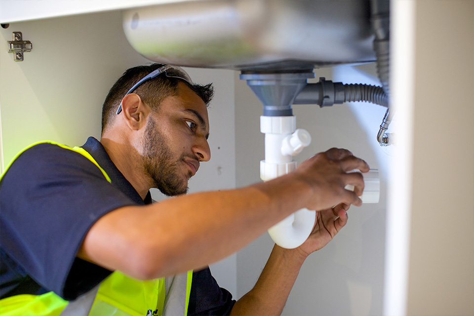 skills-plumbing Skills-male-under-sink-fixing-plumbing